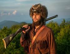 a photo of Colson wearing his mascot uniform with the mountains behind him